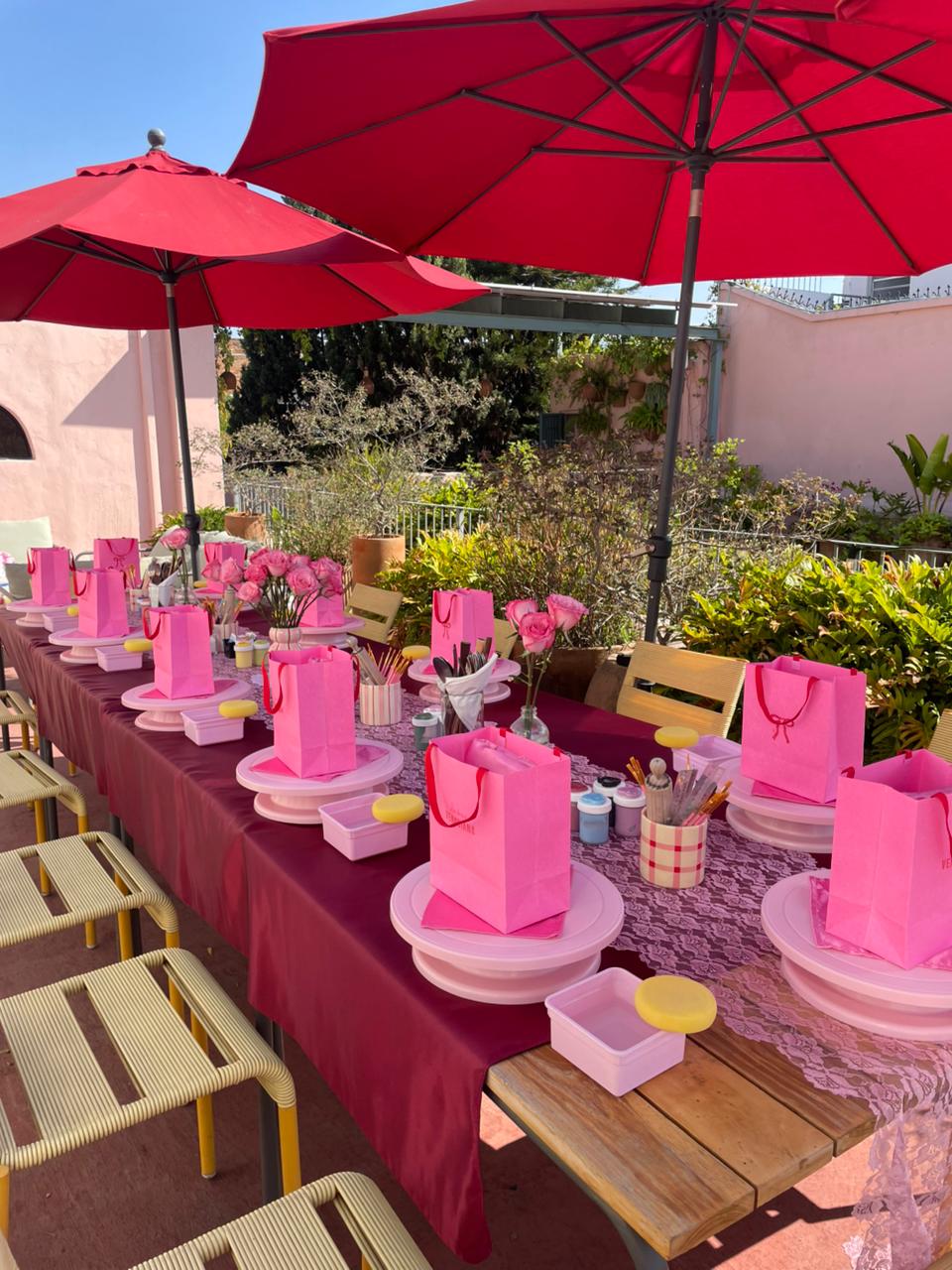 Mesa del taller montada bajo sombrillas rojas