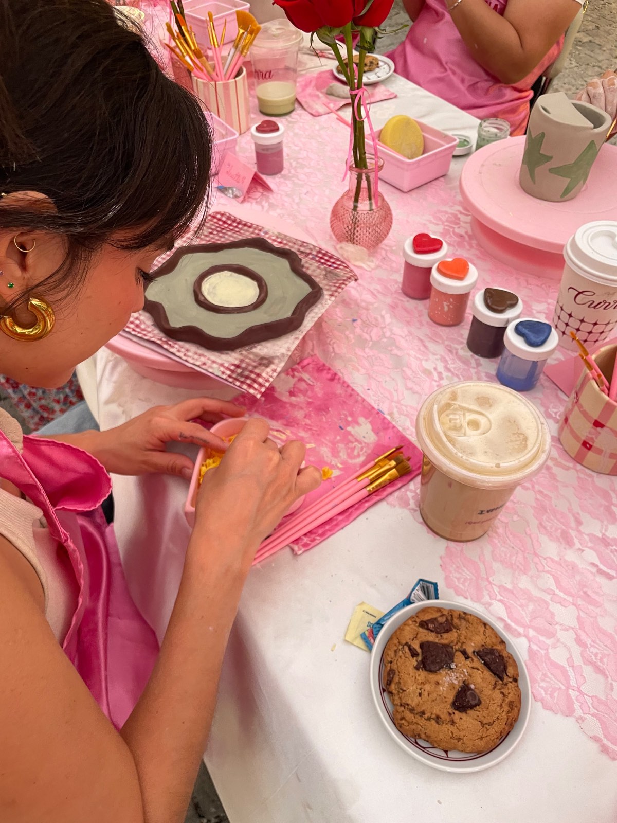 Manos pintando una pieza de cerámica durante un taller de Venusiana